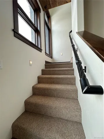 a bedroom with a bed lamp and a large window