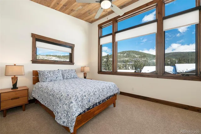 a bedroom with a bed and a large window with the outer view