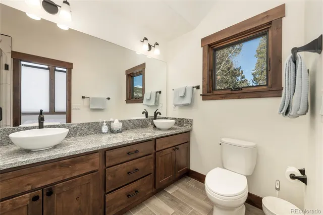 a bathroom with a granite countertop sink mirror and shower