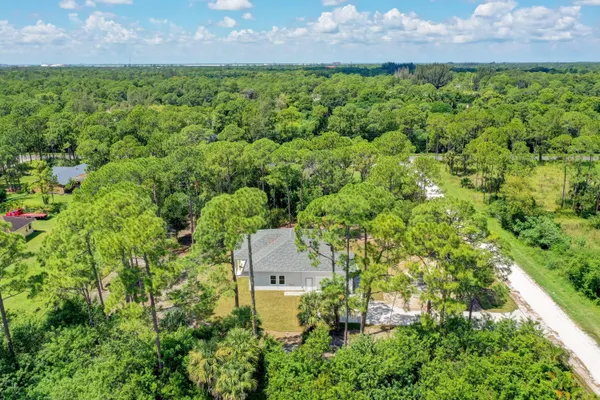 an aerial view of residential houses with outdoor space and trees