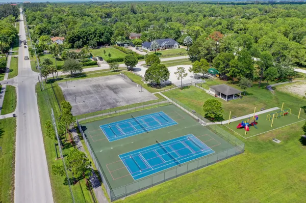 view of a tennis ground with large trees