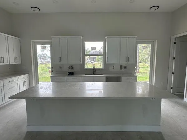 a large white kitchen with a sink