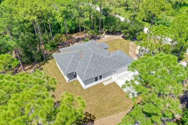an aerial view of a house with swimming pool and garden view
