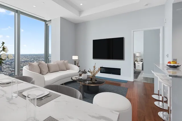 a living room with furniture a flat screen tv and a large window