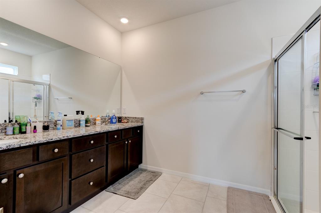 1706 Red Rock Road New Smyrna Beach, FL 32168 - Photo 22 of 27 a spacious bathroom with a double vanity sink a mirror and a shower