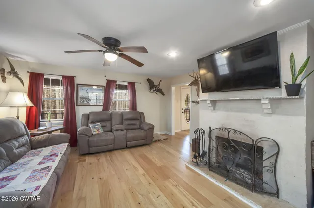 a living room with furniture ceiling fan and a window