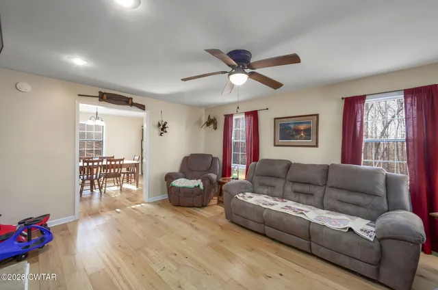 a view of a livingroom with furniture wooden floor and windows