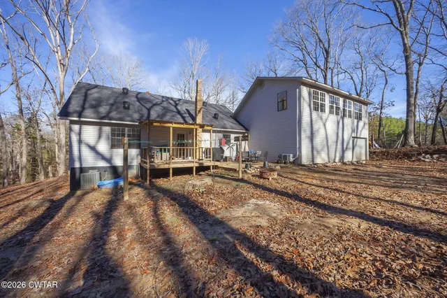 a view of a house with a large tree and wooden fence