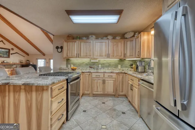 a kitchen with stainless steel appliances granite countertop a stove and a sink
