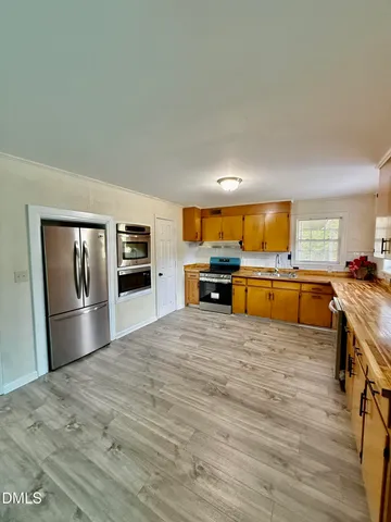 a large kitchen with stainless steel appliances granite countertop a stove and a refrigerator