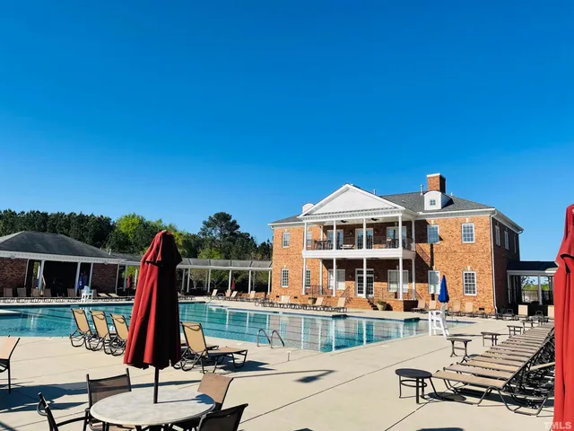 a view of a house with swimming pool and sitting area