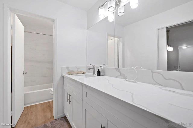 a en suite bathroom with a tub double sink and mirror
