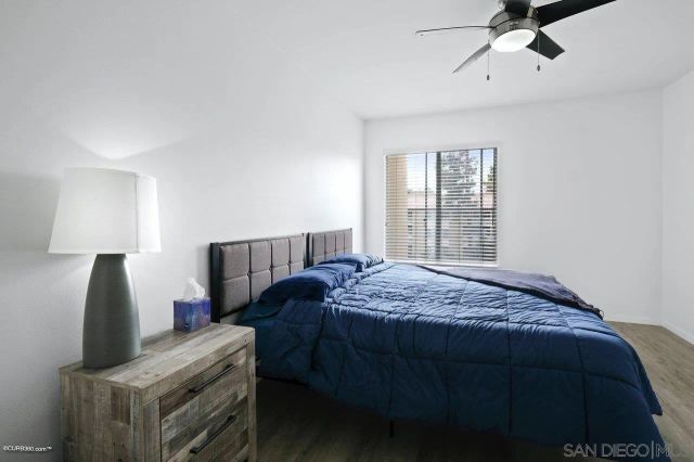 a bedroom with a bed and a flat tv screen on the dresser