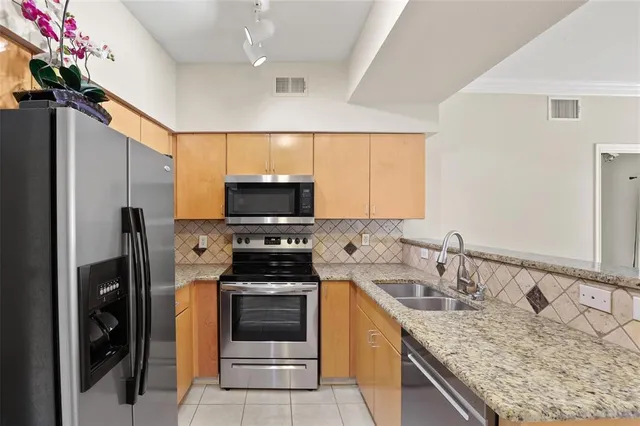 a kitchen with stainless steel appliances granite countertop a sink stove and refrigerator