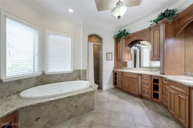 a bathroom with a granite countertop tub a sink and a mirror