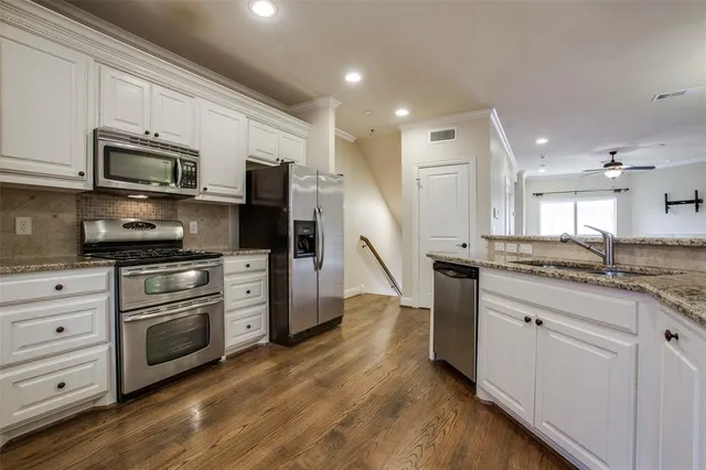 a kitchen with stainless steel appliances kitchen island granite countertop a stove a sink and a microwave