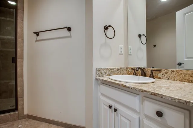 a bathroom with a granite countertop sink and a mirror