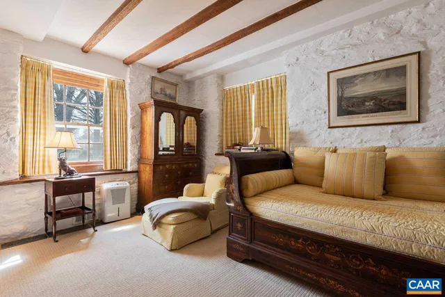 a living room with furniture and a painting on the wall