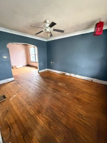 a view of an empty room with window and wooden floor