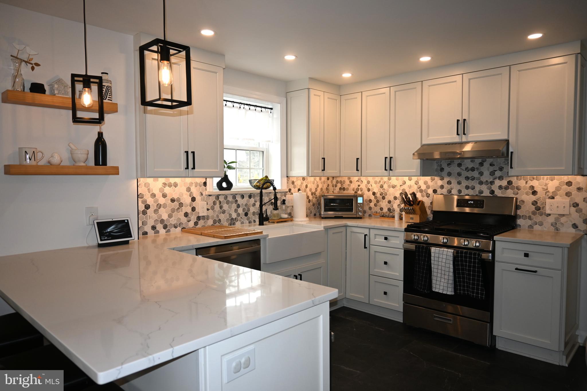 514 Springview Lane Springfield, PA 19064 - Photo 11 of 33 a kitchen with a sink a stove and cabinets