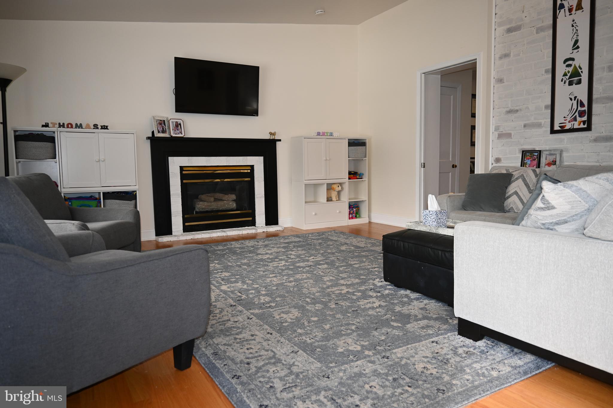 514 Springview Lane Springfield, PA 19064 - Photo 14 of 33 a living room with furniture a flat screen tv and a fireplace
