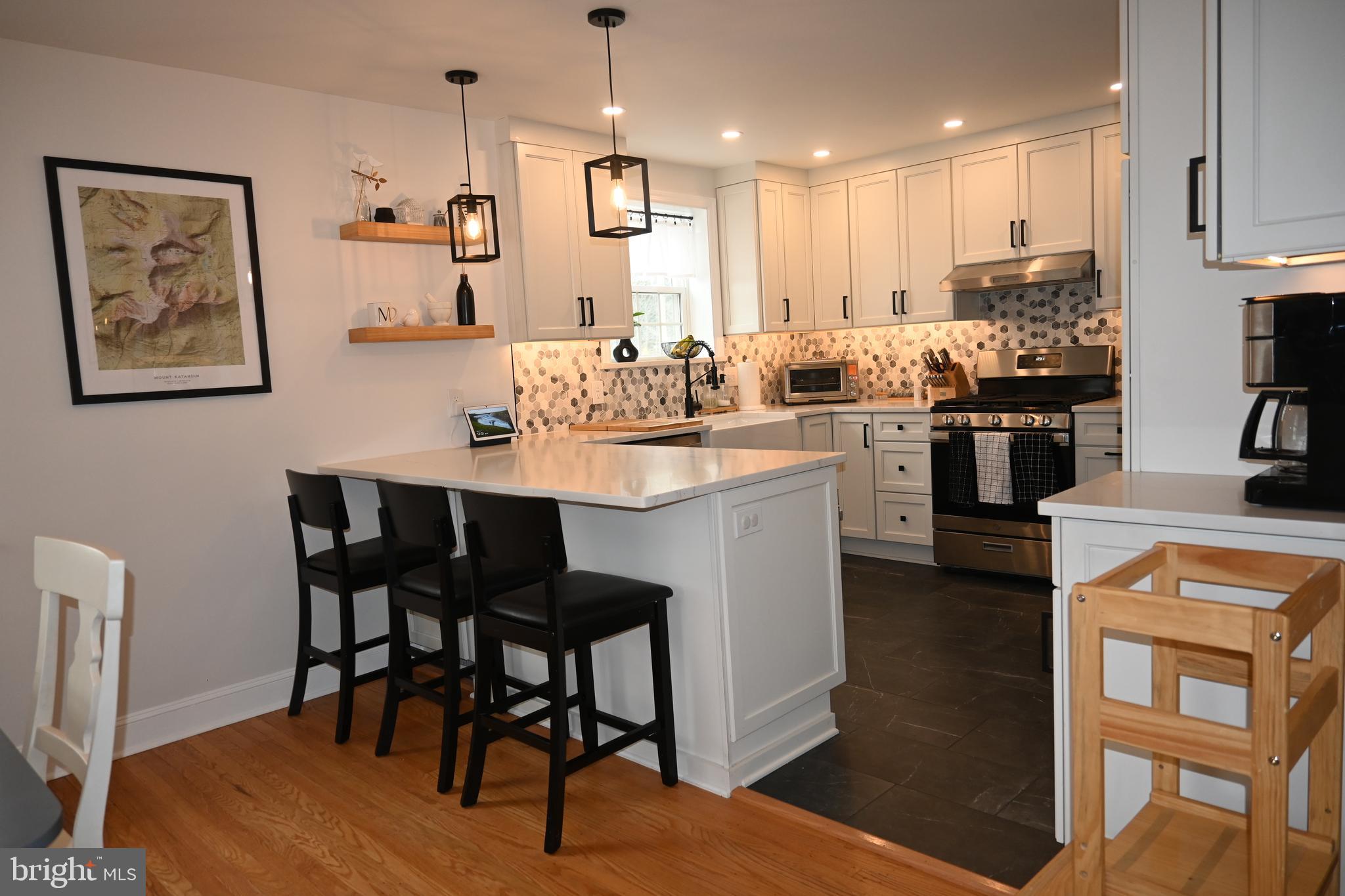 514 Springview Lane Springfield, PA 19064 - Photo 7 of 33 a kitchen with stainless steel appliances kitchen island granite countertop a table chairs and a refrigerator