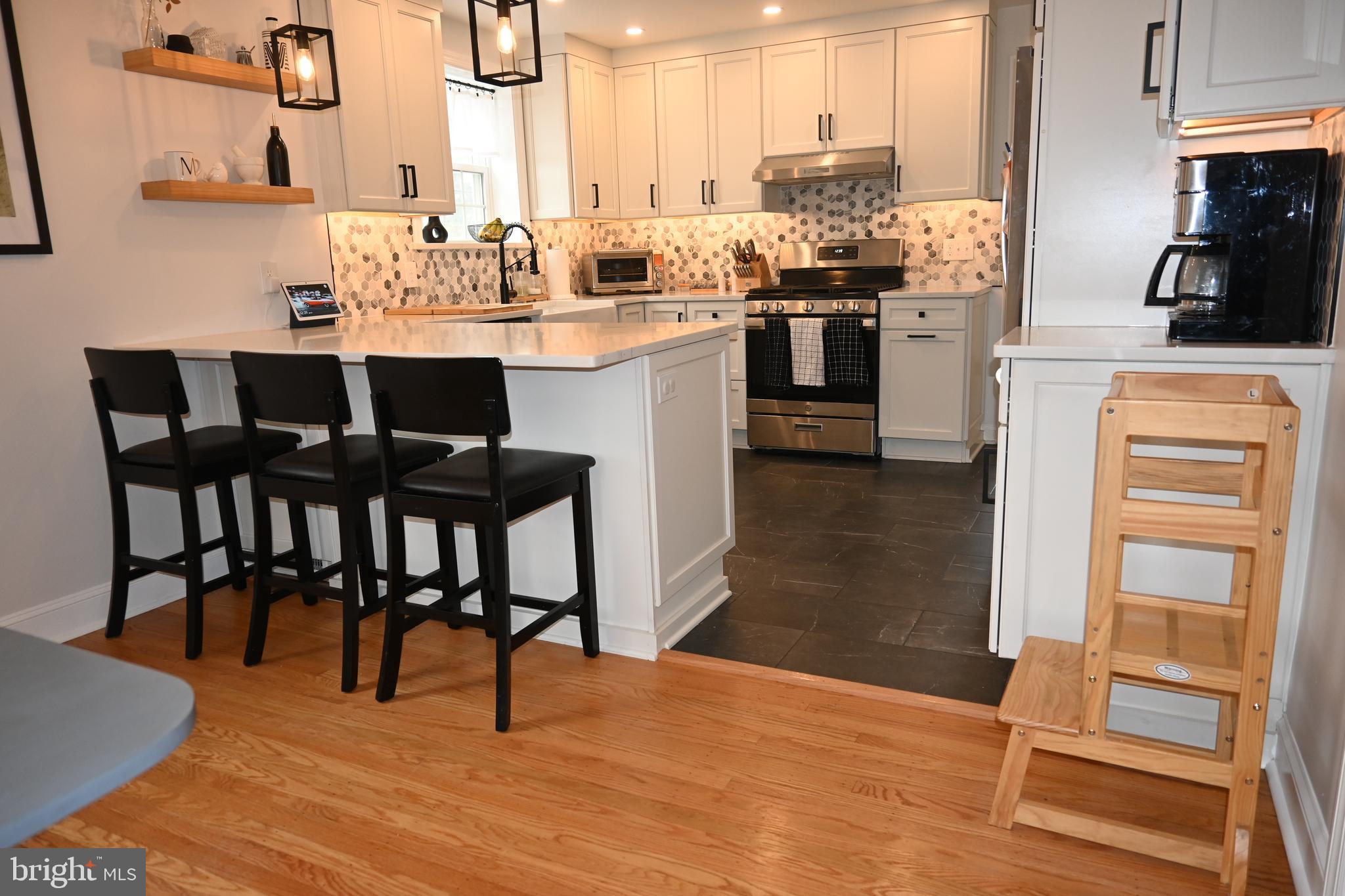 514 Springview Lane Springfield, PA 19064 - Photo 9 of 33 a kitchen with stainless steel appliances kitchen island granite countertop a table chairs sink and cabinets