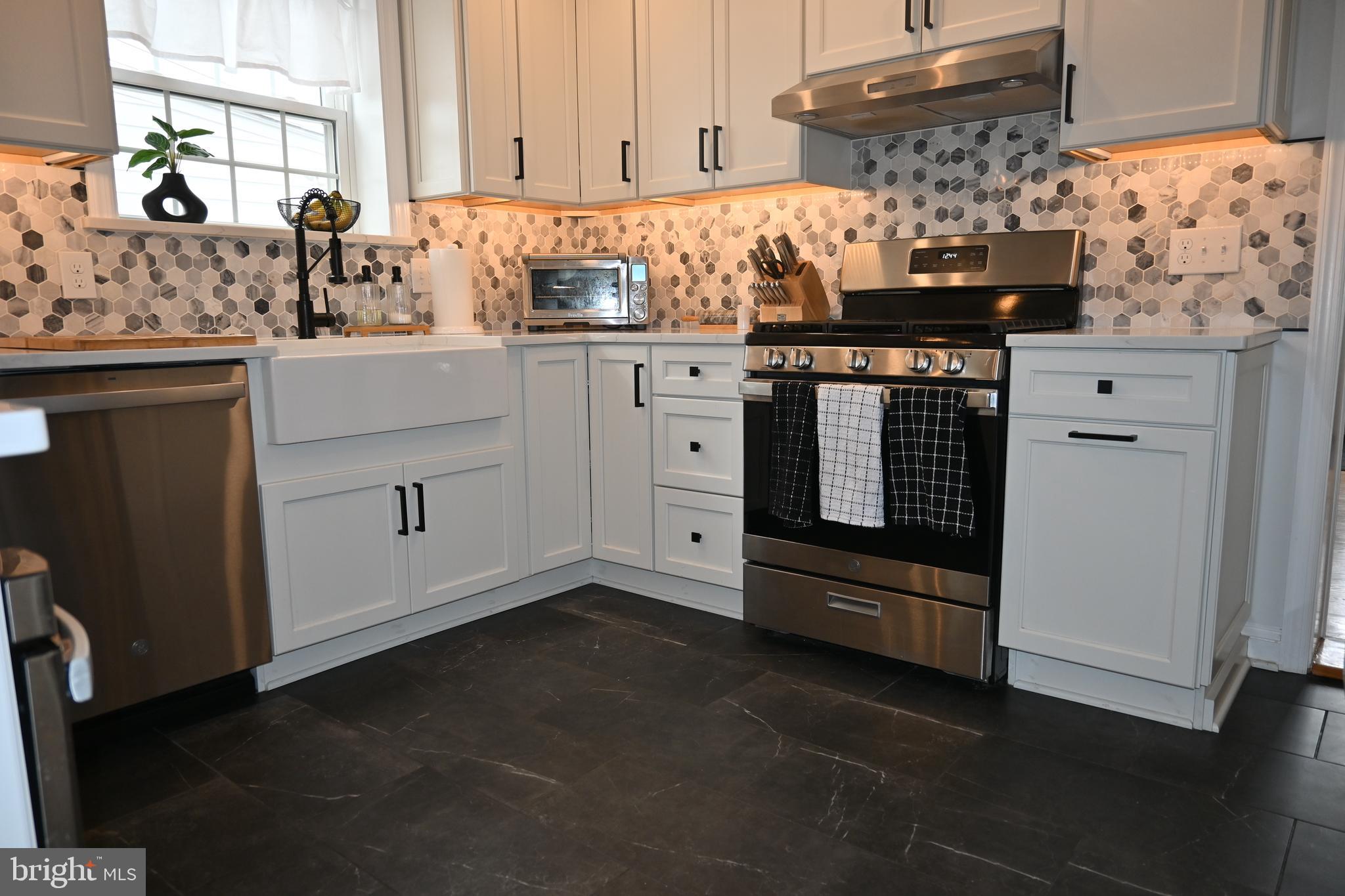 514 Springview Lane Springfield, PA 19064 - Photo 10 of 33 a kitchen with stainless steel appliances granite countertop a stove and a sink