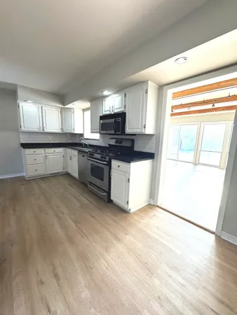 a kitchen with stainless steel appliances granite countertop a stove a sink and a microwave