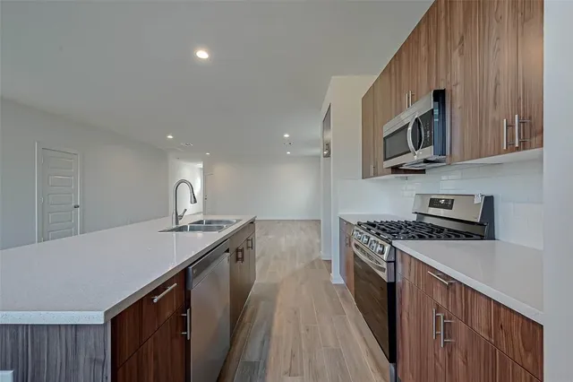 a kitchen with stainless steel appliances granite countertop a sink stove and microwave