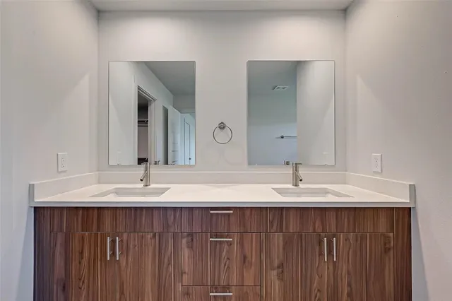 a bathroom with double vanity sinks and a mirror