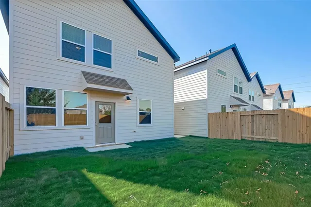 a view of a house with a yard and fence