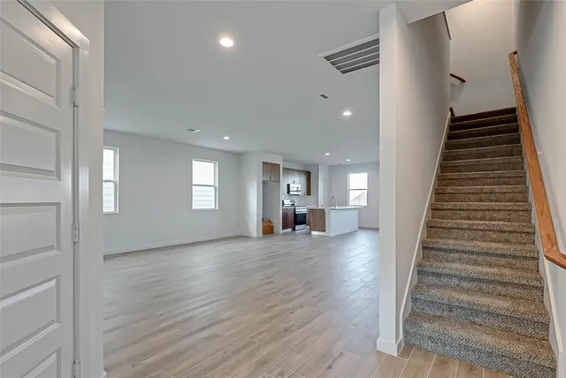 a view of a livingroom with wooden floor and stairs