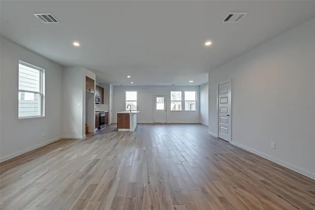 a view of empty room with wooden floor and window