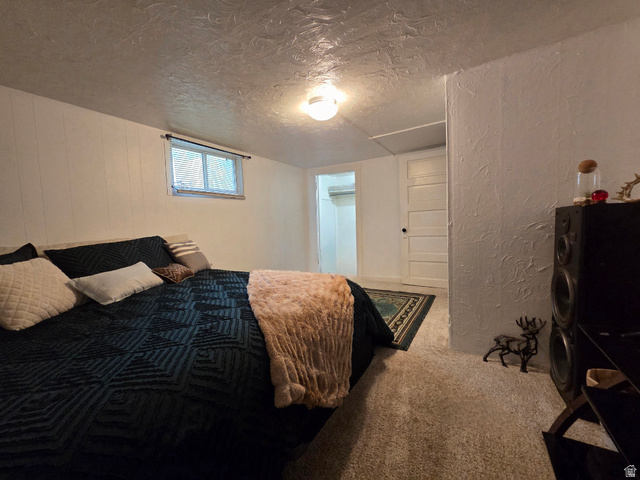 142 West 400 North Logan, UT 84321 - Photo 23 of 35 Carpeted room featuring a single window with blinds, white paneled walls, and a textured ceiling