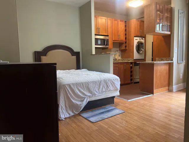 a bedroom with a bed and a refrigerator