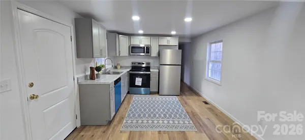a kitchen with kitchen island wooden cabinets a refrigerator sink and wooden floor