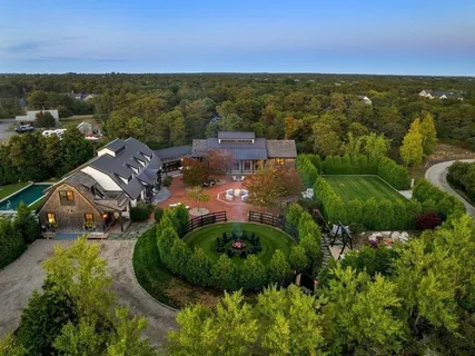 an aerial view of residential houses with outdoor space and trees