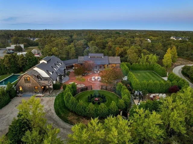 an aerial view of residential houses with outdoor space and trees