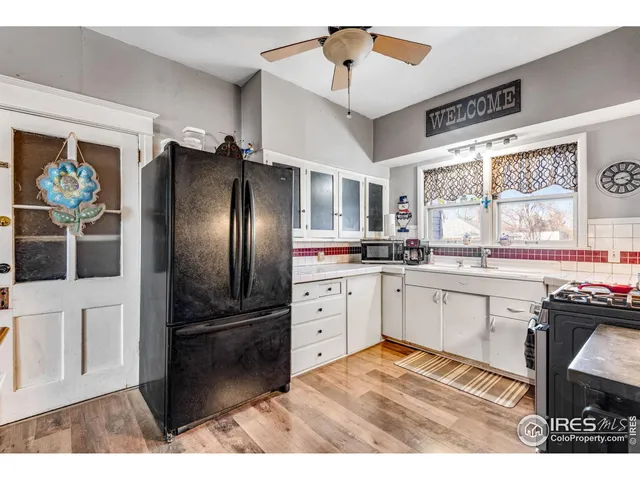 a kitchen with granite countertop a refrigerator stove top oven and sink