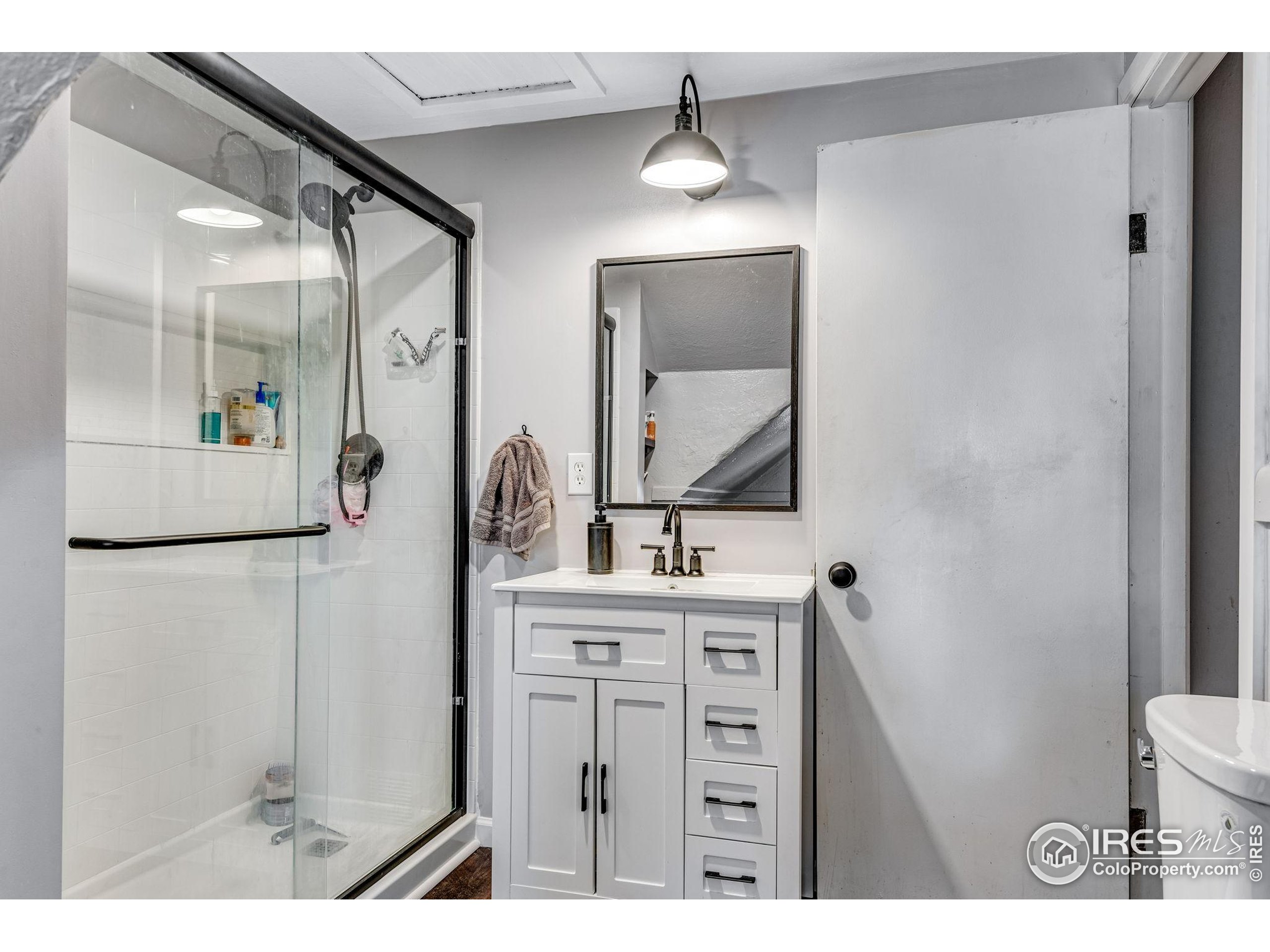 501 Maple Street Fort Morgan, CO 80701 - Photo 40 of 46 a bathroom with a sink a mirror a toilet and vanity