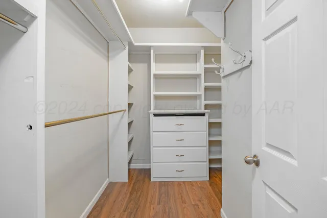 a view of walk in closet with empty racks