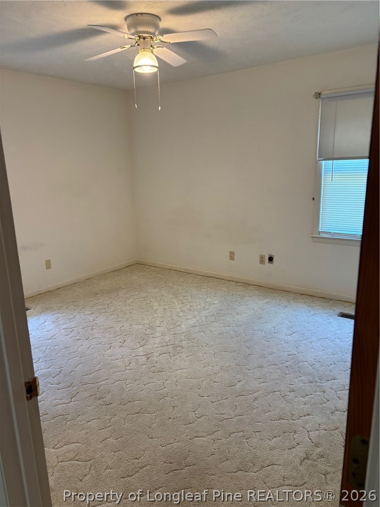 1523 Proctorville Church Road Proctorville, NC 28369 - Photo 29 of 35 an empty room with a ceiling fan and carpet
