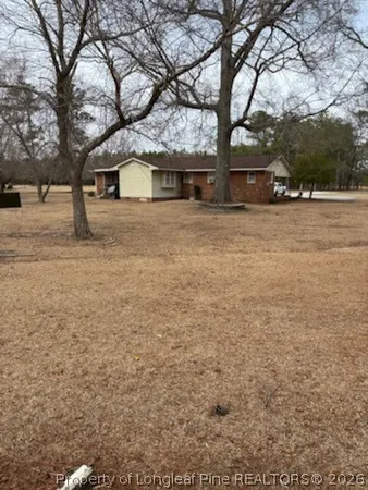 a front view of a house with large trees