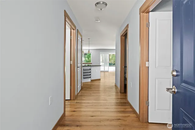 a view of a hallway with wooden floor and a living room