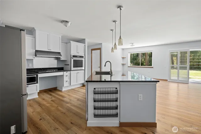 a kitchen with granite countertop a stove a sink and a refrigerator