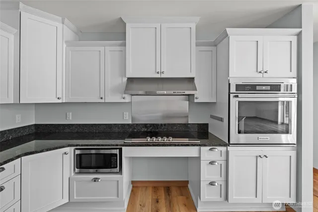 a kitchen with white cabinets and black appliances