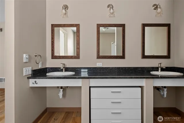a bathroom with a granite countertop sink and a mirror