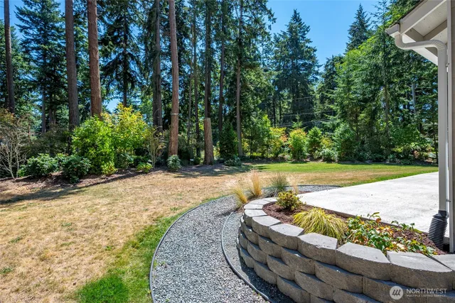 a front view of a house with a yard and large trees