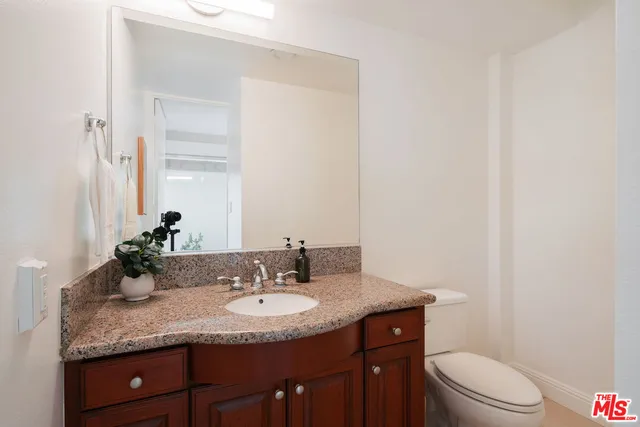 a bathroom with a granite countertop sink and a mirror